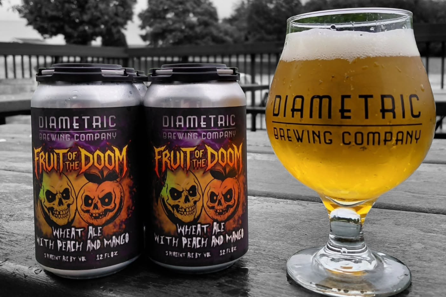 glass of beer with diametric brewing company logo and cans of beer labeled fruit of the doom